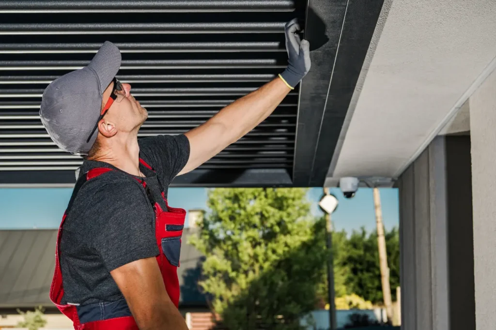 Skilled installer working on pergola louvres for Pergolas Christchurch with Deck Builders Christchurch.